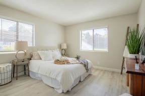 a bedroom with a bed and two windows