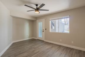 an empty bedroom with a ceiling fan and a window