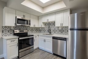 a kitchen with white cabinets and stainless steel appliances