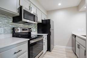 A kitchen with black appliances and white cabinets at Sofia Apartments, Tempe, 85283