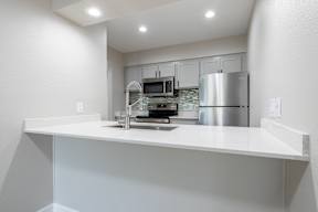 A modern kitchen with a stainless steel refrigerator and a white countertop at Sofia Apartments, Tempe, 85283