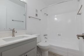 A white toilet sits next to a white sink in a white bathroom at Sofia Apartments, Tempe, 85283
