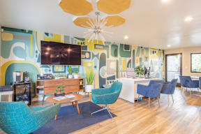 a living room with blue chairs and a table and a television
