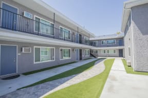 the outlook of a building with balconies and green grass