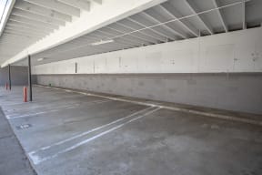 a parking garage with white walls and a concrete floor