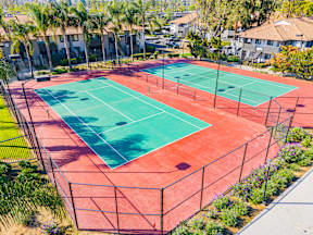 A tennis court surrounded by a fence and trees at Metro 3610, Riverside, 92505