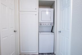 A white washing machine is in a small laundry room.