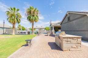 the backyard has a grill and a picnic table and palm trees at Villas on Olive, Peoria, Arizona