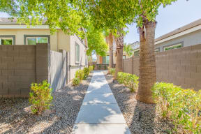 a long walkway with trees in front of a house at Villas on Olive, Peoria, Arizona