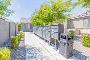a driveway with a fence and a trash can in front of a house at Villas on Olive, Peoria, Arizona