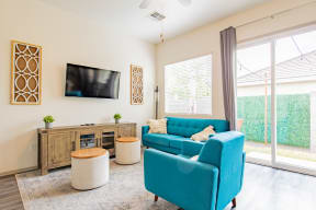 a living room with a blue couch and a tv at Villas on Olive, Peoria, Arizona
