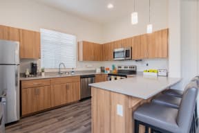 a kitchen with wooden cabinets and a white counter top at Villas on Olive, Peoria, Arizona