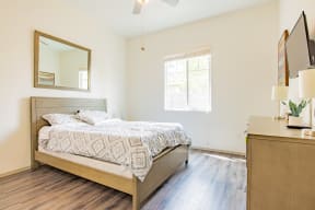 a bedroom with a bed and a dresser and a window at Villas on Olive, Peoria, Arizona