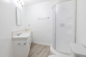 a bathroom with a shower and a sink and a toilet