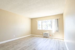 an empty room with wood floors and a window