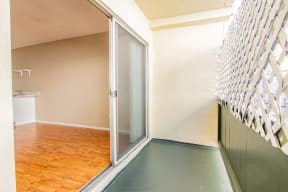 an empty room with a sliding glass door to a bathroom