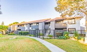 A modern apartment building with a black fence and a sidewalk at Metro 3610, Riverside, 92505
