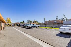A parking lot with cars and a building in the background.