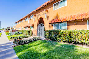 A building with a red tile roof and a sign that says "Pomona College" on it.