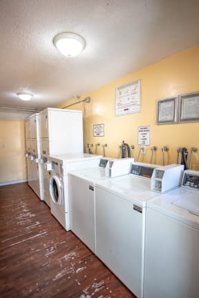 a laundry room with several washes and dryers in it
