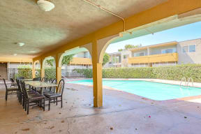 a patio with a swimming pool and a table and chairs
