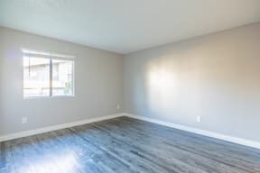 an empty room with wood floors and a window