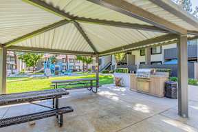 A covered picnic area with a grill and a table at Metro 3610, Riverside, 92505
