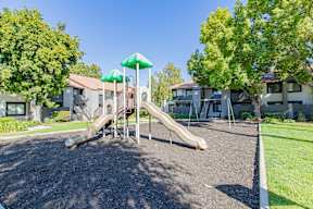 A playground with a green umbrella and a slide at Metro 3610, Riverside, 92505
