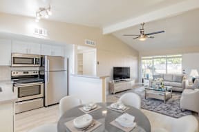 A modern kitchen with a dining table set for two.