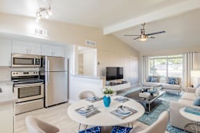 A modern kitchen with a dining area and a living room.