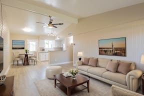 A living room with a couch, chairs, and a painting on the wall.