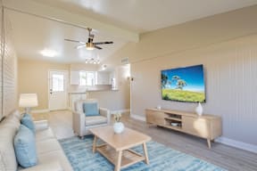 A living room with a television and a white couch.