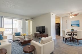 A living room with a television, a dining table, and chairs at Sofia Apartments, Tempe, 85283