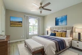 A bedroom with a large bed, a ceiling fan, and two pictures on the wall at Sofia Apartments, Tempe, 85283