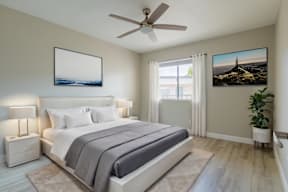 A bedroom with a large bed, a ceiling fan, and a painting on the wall at Sofia Apartments, Tempe, 85283