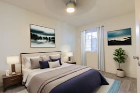 A bedroom with a large bed and two pictures on the wall.