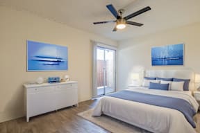 A bedroom with a large bed and a ceiling fan.