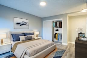 A bedroom with a large bed and a painting above it.