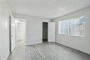 an empty living room with white walls and wood flooring