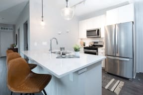 a kitchen with a large island and stainless steel appliances