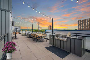 a rooftop bar with a view of the city and a sunset