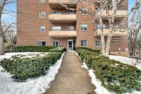 a brick apartment building with balconies and snow on the ground