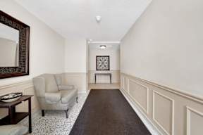 a living room with white walls and a dark rug