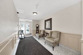a living room with two chairs and a grandfather clock