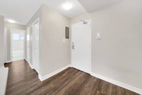 a bedroom with hardwood flooring and white walls