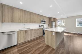 a kitchen with white countertops and wooden cabinets