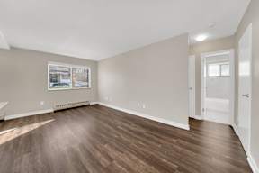 a bedroom with hardwood floors and grey walls