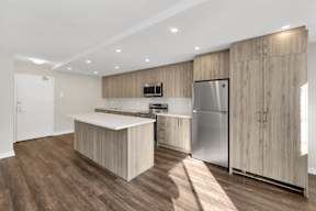 a kitchen with wooden cabinets and an island with a white countertop
