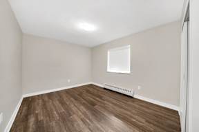 a bedroom with hardwood floors and grey walls