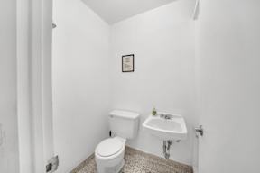 a bathroom with a toilet sink and shower in a 555 waverly unit